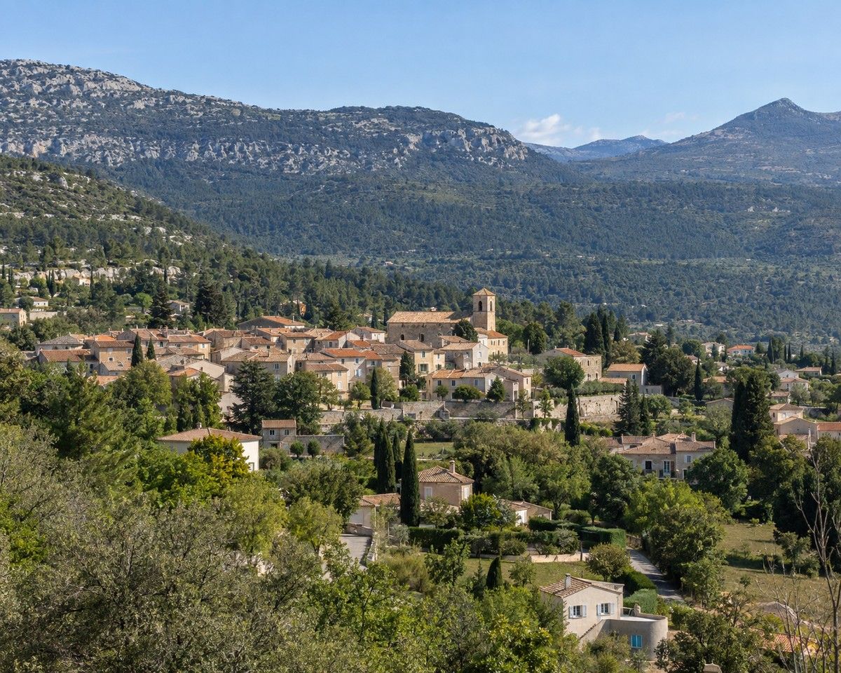 Vue générale réaliste de Saint-Vallier-de-Thiey, de son village et des reliefs boisés des Préalpes