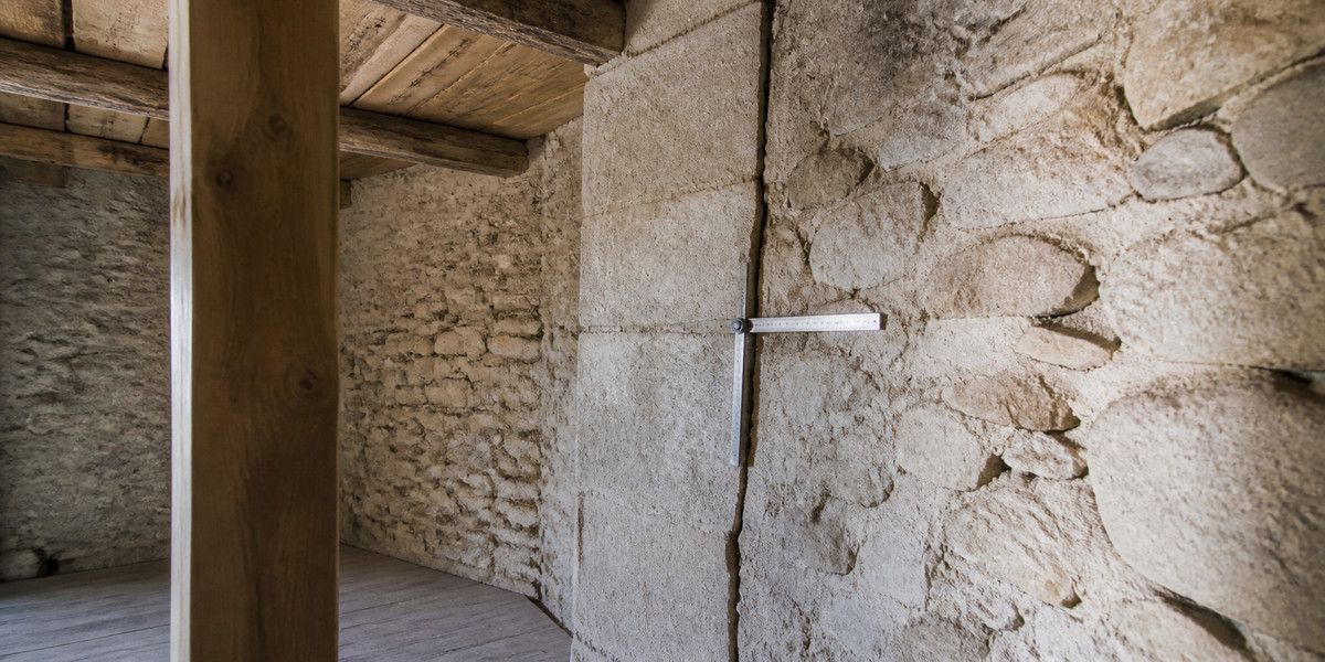 Jonction fissurée entre deux maçonneries anciennes examinée dans une maison en pierre