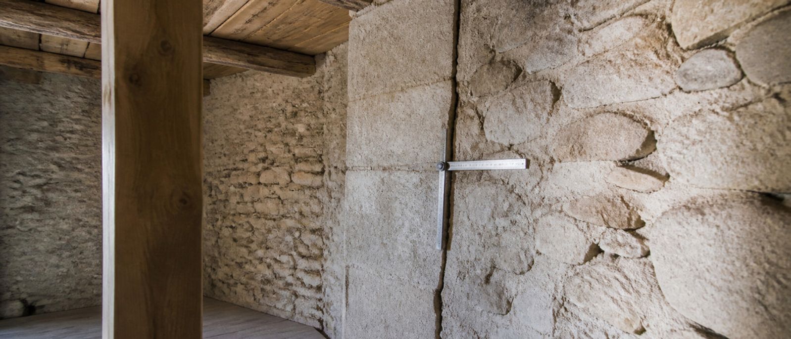 Jonction fissurée entre deux maçonneries anciennes examinée dans une maison en pierre