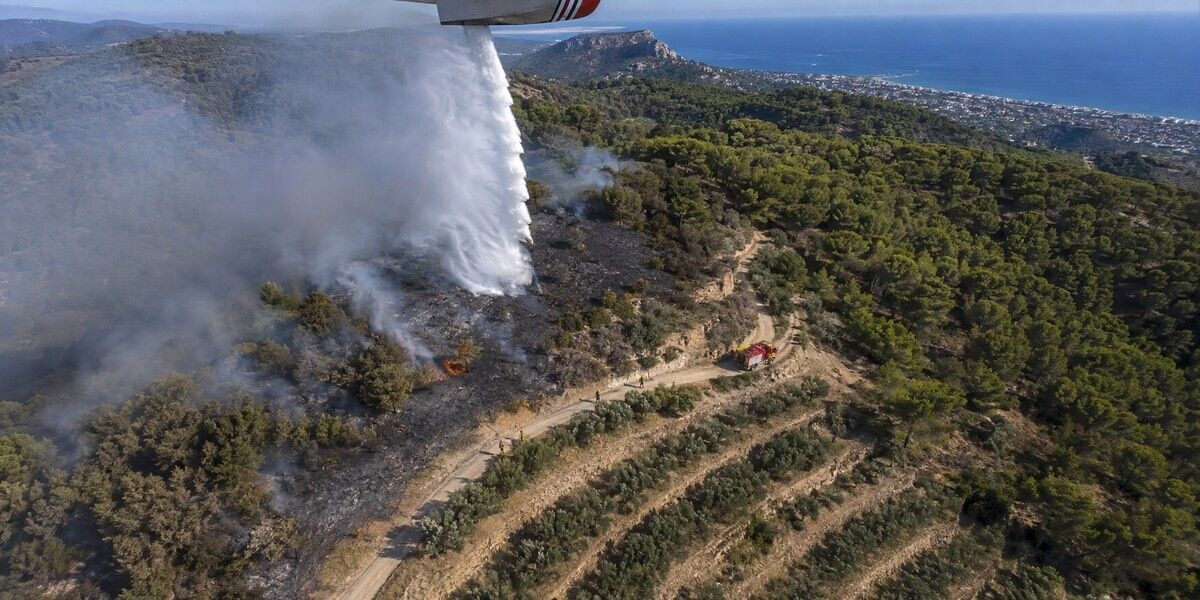 Vue aérienne d’un largage d’eau sur un feu de forêt progressant près des collines de Cagnes-sur-Mer
