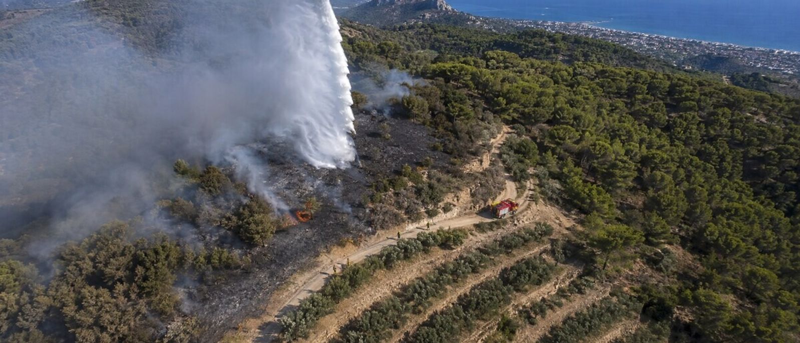 Vue aérienne d’un largage d’eau sur un feu de forêt progressant près des collines de Cagnes-sur-Mer
