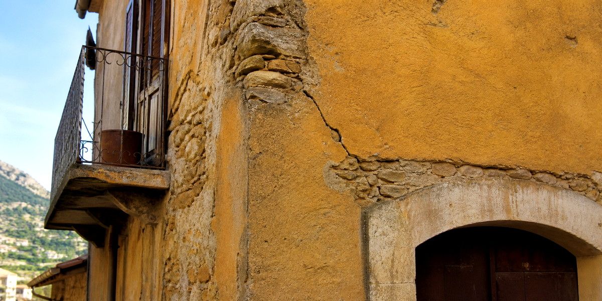 Fissure diagonale sur la maçonnerie ancienne d’une maison du village de Roquebrune-Cap-Martin.