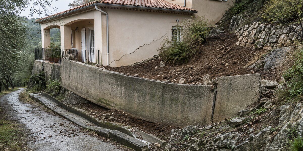 Mur de soutènement déplacé, terrain glissé et fissure sur une villa implantée sur un versant méditerranéen évoquant Grasse