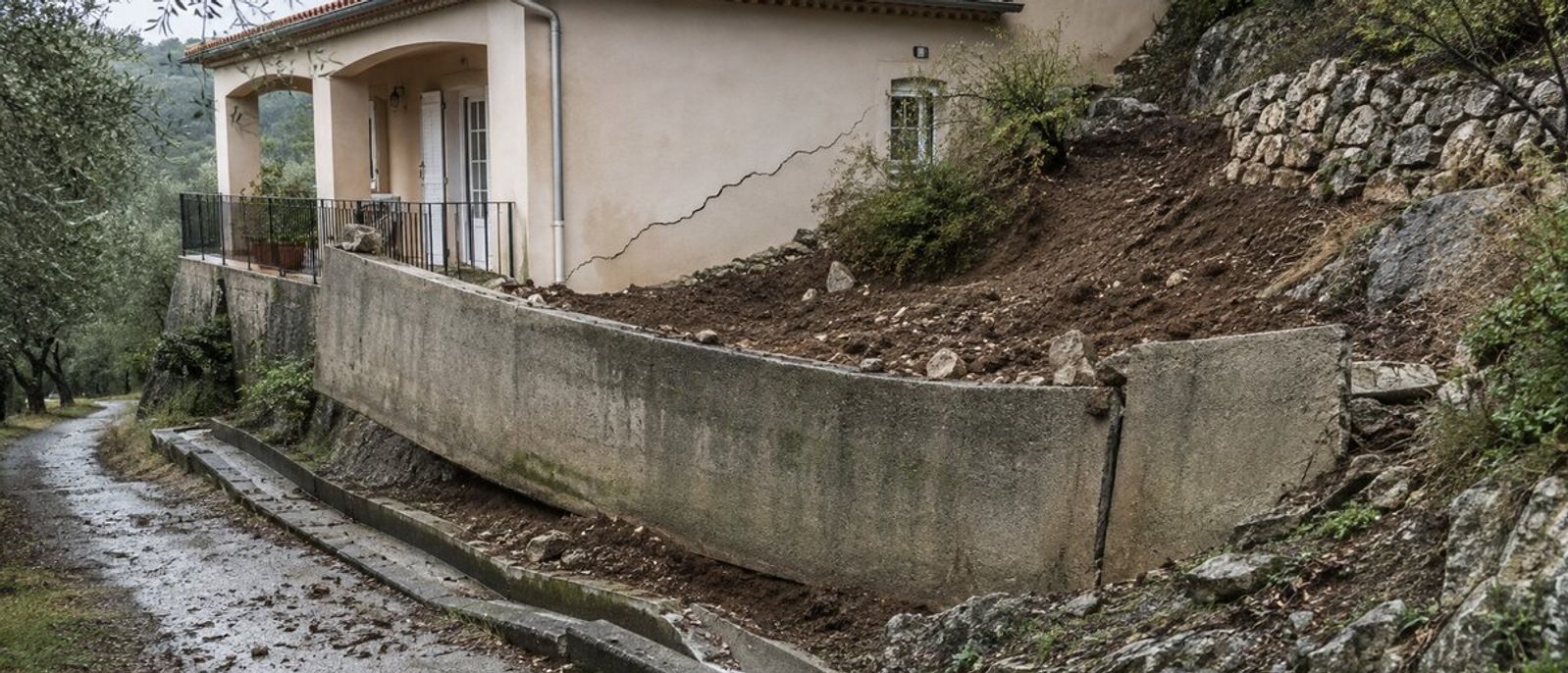 Mur de soutènement déplacé, terrain glissé et fissure sur une villa implantée sur un versant méditerranéen évoquant Grasse