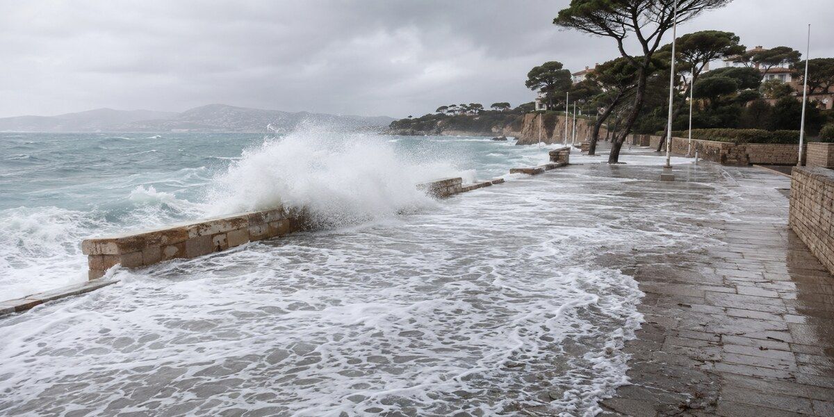 Vagues de tempête franchissant un muret côtier et recouvrant une promenade méditerranéenne évoquant le littoral du Cap d’Antibes