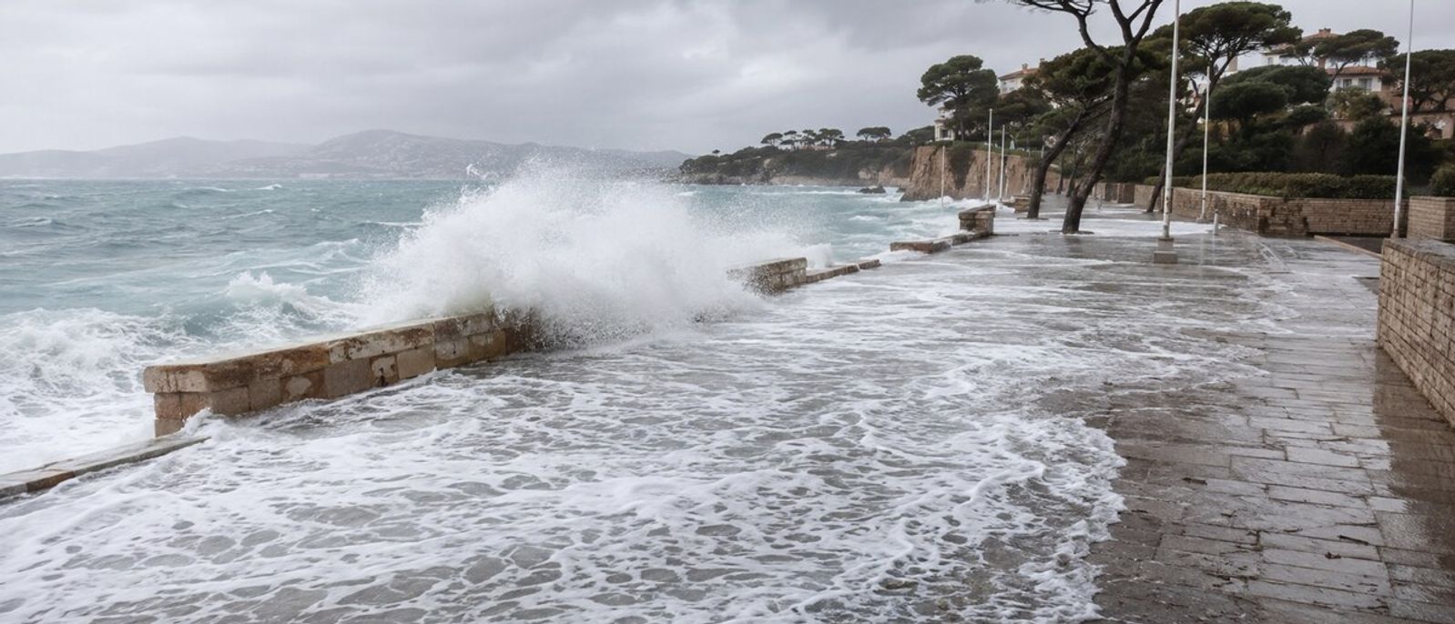 Vagues de tempête franchissant un muret côtier et recouvrant une promenade méditerranéenne évoquant le littoral du Cap d’Antibes