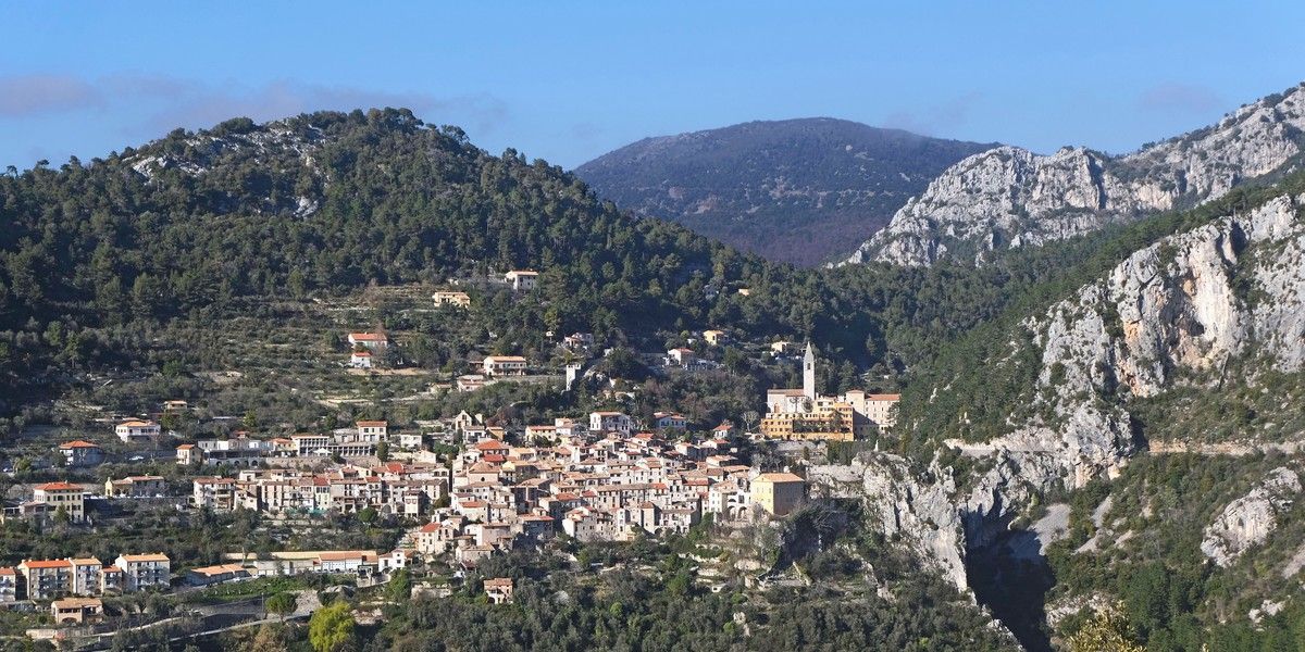Village de Peille entouré de versants boisés et de reliefs rocheux