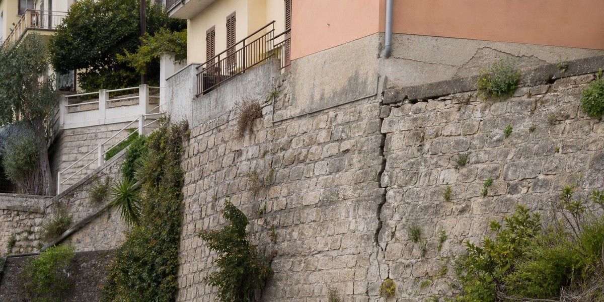 Mur de soutènement et bâtiment en terrain aménagé illustrant l’examen structurel en zone sismique