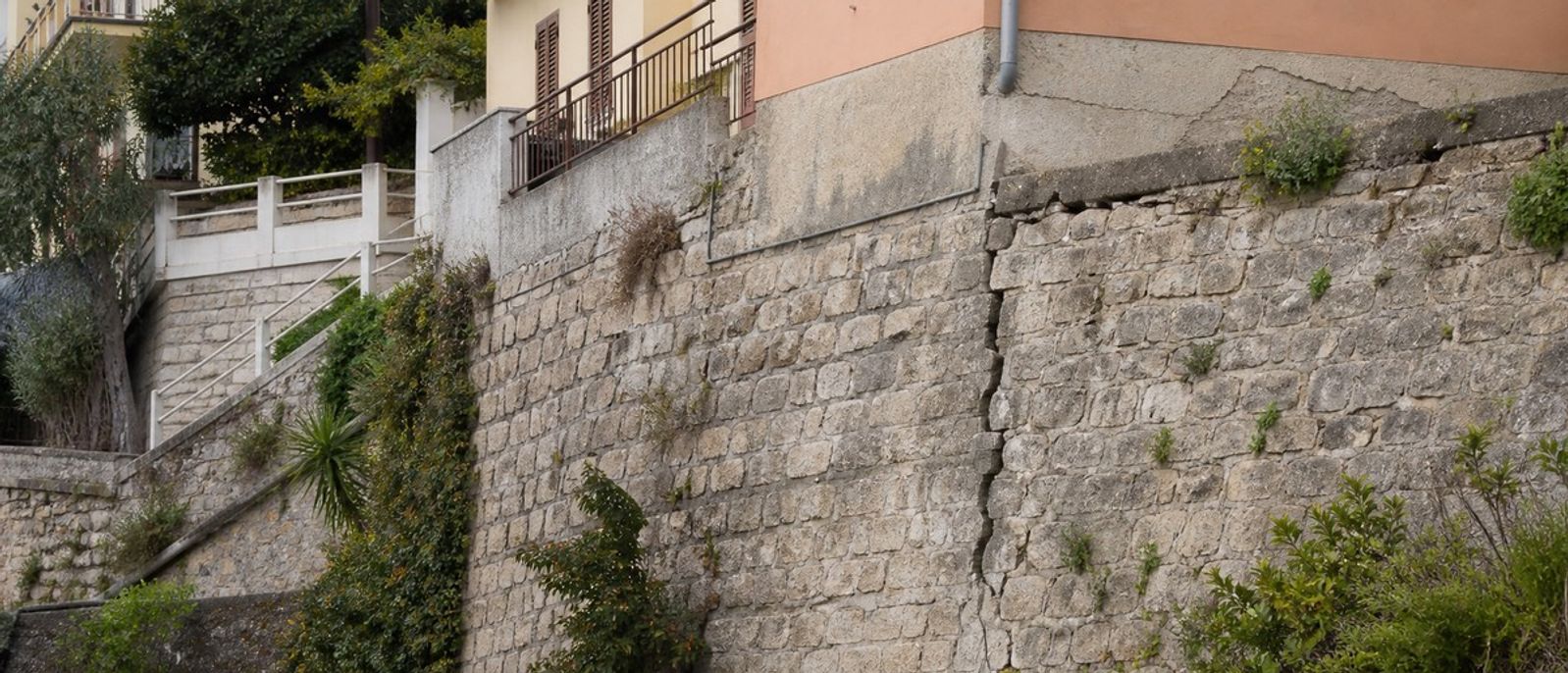 Mur de soutènement et bâtiment en terrain aménagé illustrant l’examen structurel en zone sismique