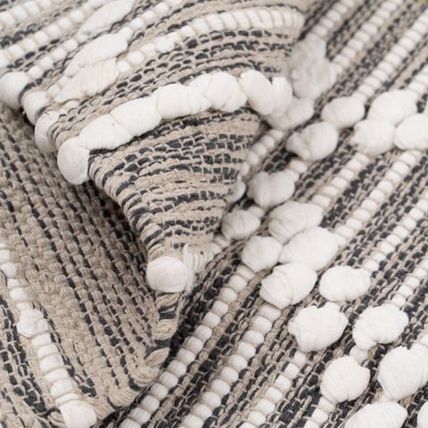 Alfombra gris y blanca de rombos con relieve — detalle