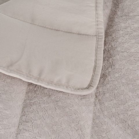 Colcha beige con acolchado de paneles — detalle