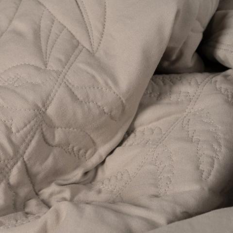 Colcha taupe con acolchado de hojas — detalle