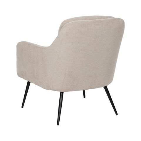 Vista posterior del sillón beige y sus patas de metal