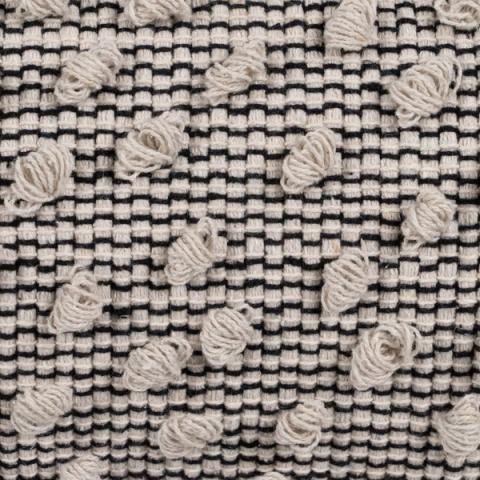 Cojín beige y negro con borlas — detalle