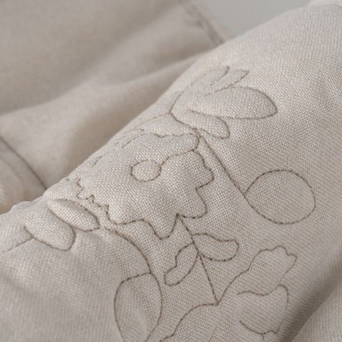 Colcha beige con acolchado floral — detalle