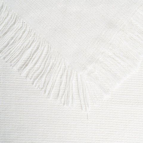 Detalle del borde con flecos de la colcha crema de algodón reciclado