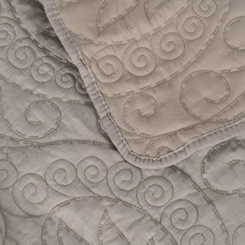 Colcha taupe de motivos ornamentales — detalle