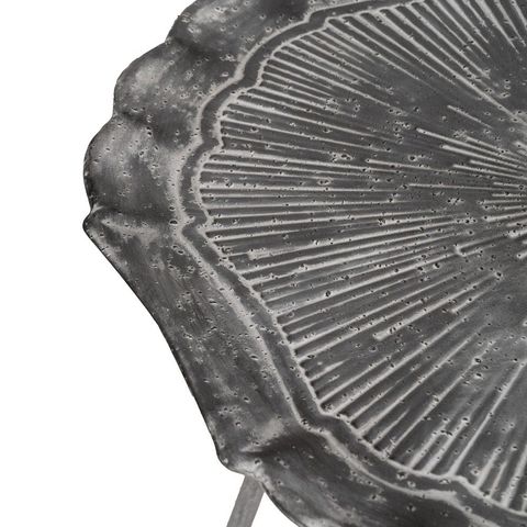 Mesa auxiliar gris con patas finas, detalle del relieve del tablero