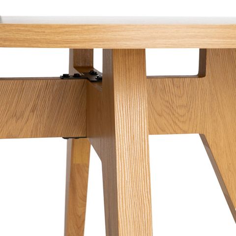 Mesa de comedor redonda con patas facetadas, detalle de las patas