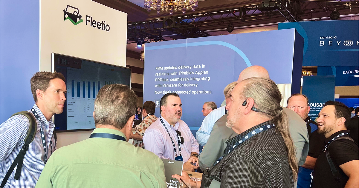 Fleet professionals engaging at a booth during the Samsara Beyond conference, discussing technology solutions for fleet management and optimization.
