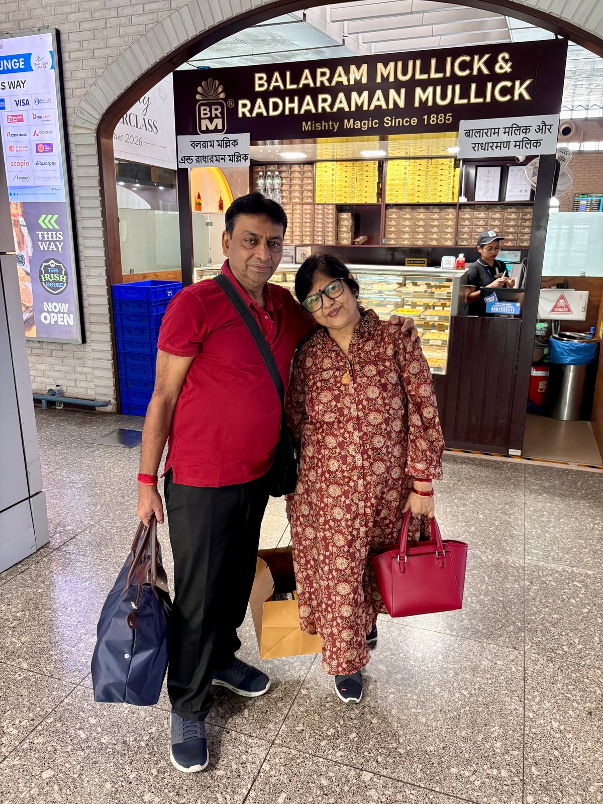 Ma and Papa at Kolkata's Netaji Subhas Chandra Bose airport before departure, stopping at the iconic Balaram Mullick & Radharaman Mullick — a sweetshop that has been a Kolkata institution since 1885.