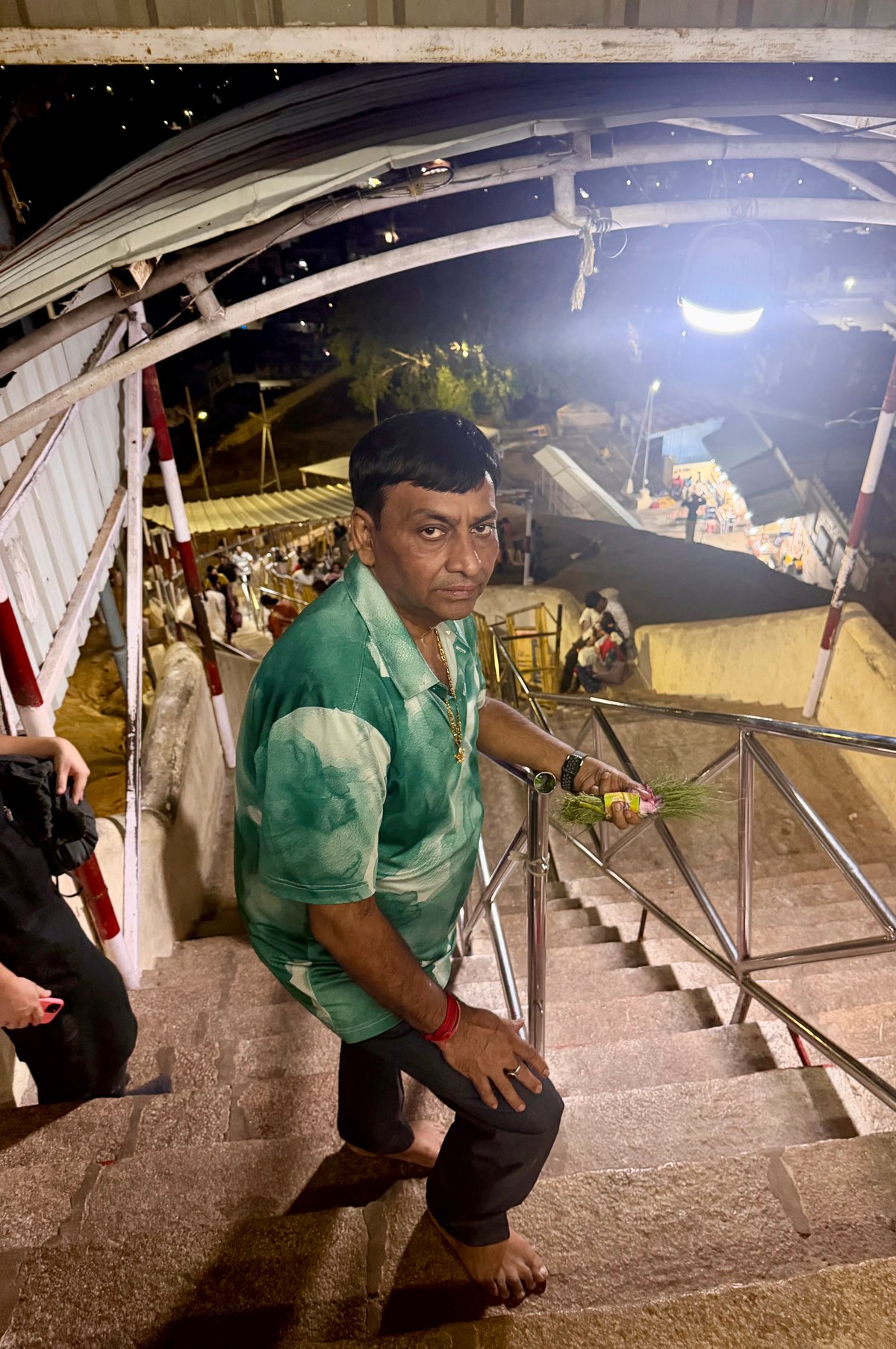 Coming down from Ucchi Pillayar after darshan — prasad (doob grass and flowers) still in hand, the city lit up far below. There's a particular kind of tiredness that only a steep temple climb gives you. The good kind.