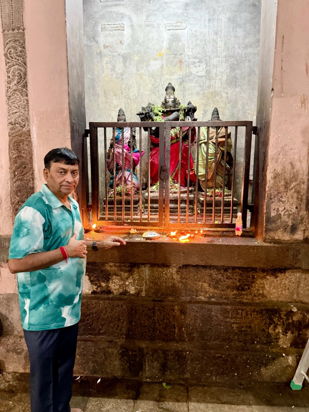 Papa at a side shrine, lamps just lit