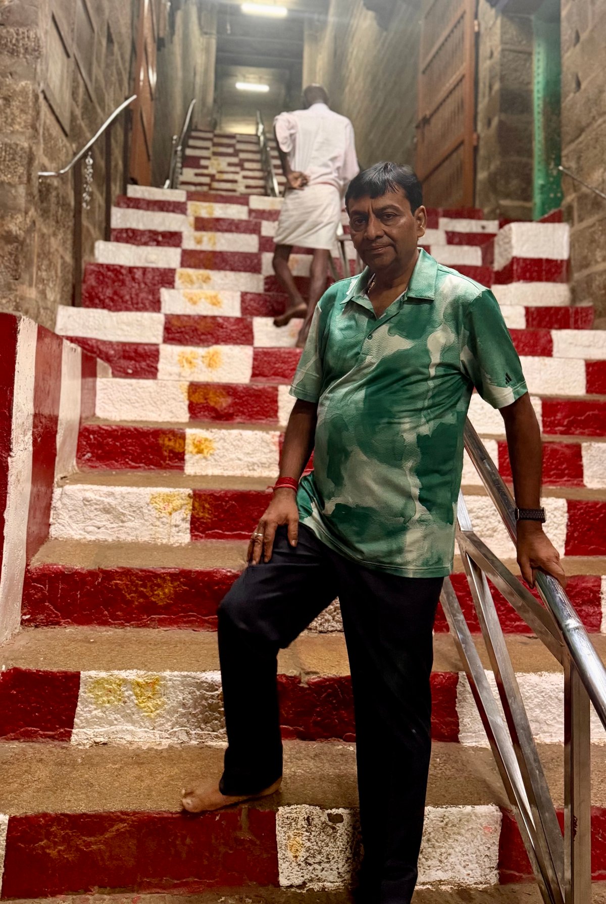 The red-and-white stairs of Rockfort — 83 metres of solid granite, painted in the temple's colours, carved right into a 3.8-billion-year-old rock. Every step up feels earned. Shiv on his way to the top.