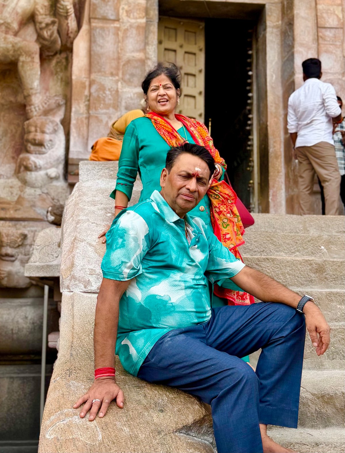 Ma and Papa on the stone steps after darshan — tired in the best way, barefoot on ancient floors, prasad in hand. The temple wears you down and fills you up at the same time.