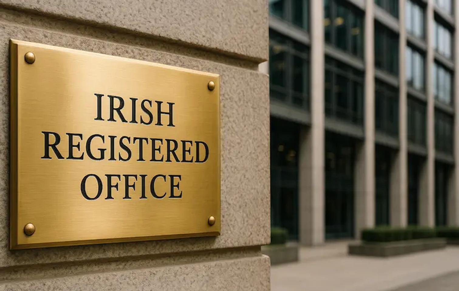 photograph-style image focused on a gold plaque reading “Irish Registered Office,” mounted outside a large, modern office building