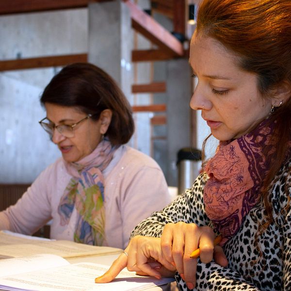 Dos mujeres leen y estudian textos juntas en un círculo de estudio