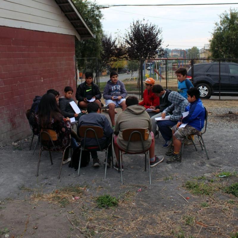 Un círculo de estudio de pre-jóvenes reunido al aire libre