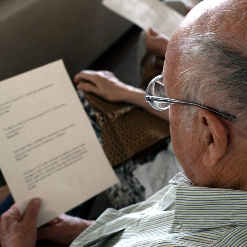 Un participante lee un libro de oraciones durante una reunión comunitaria