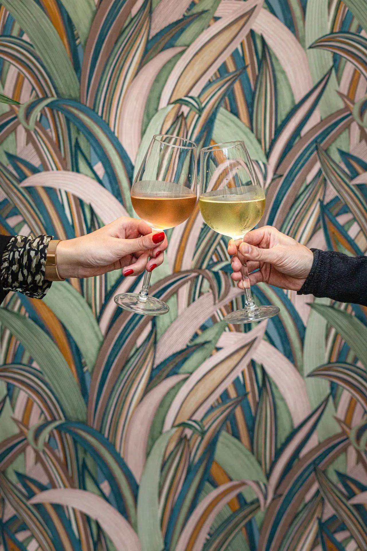Two hands toasting glasses of white wine