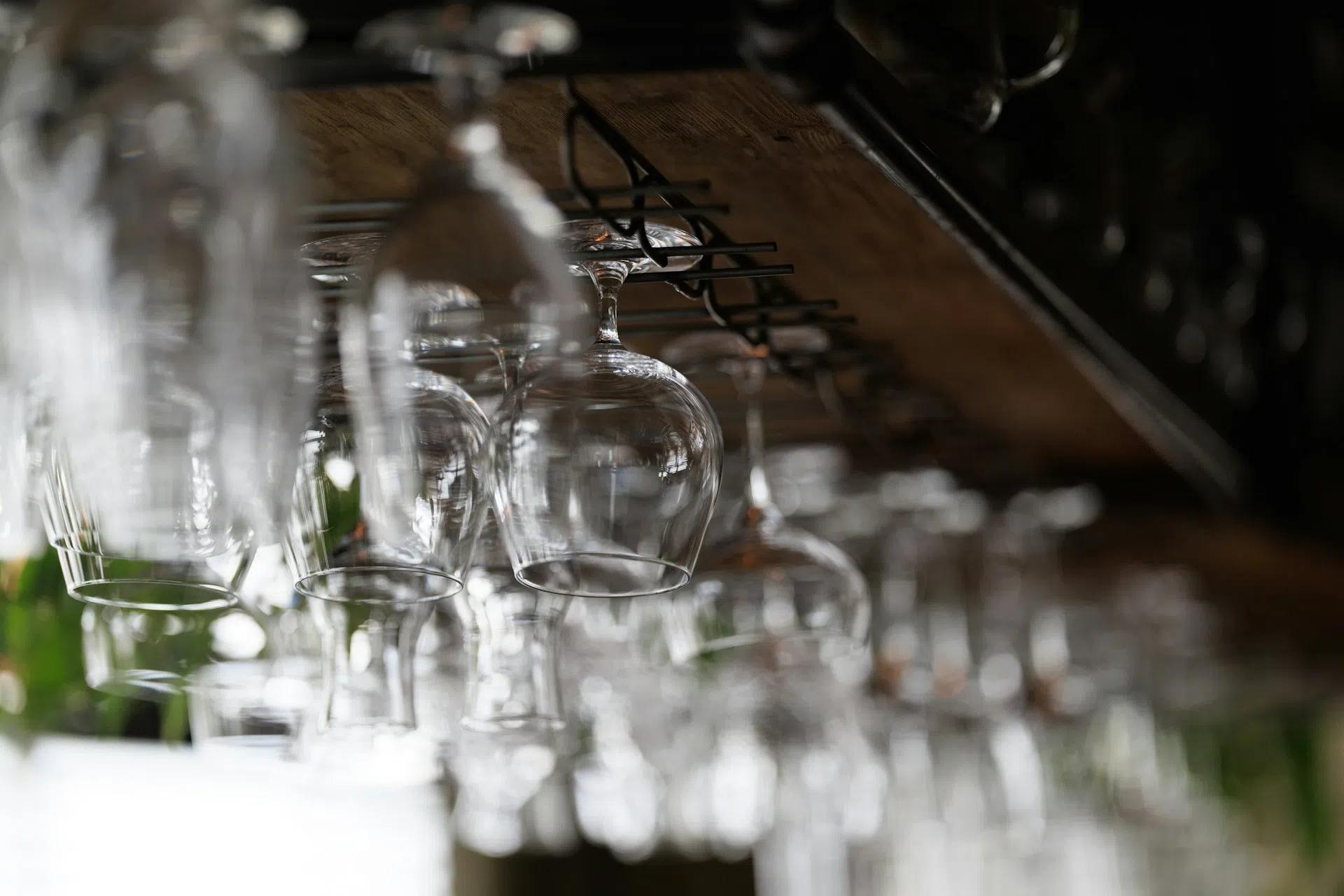 A closeup shot of a wine glass rack with wine glasses hanging on it