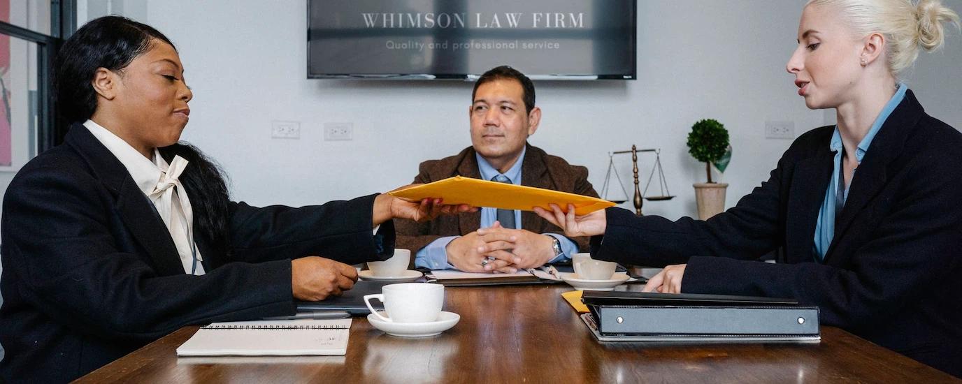 A diverse team of professionals discussing a project at Whimson Law Firm office