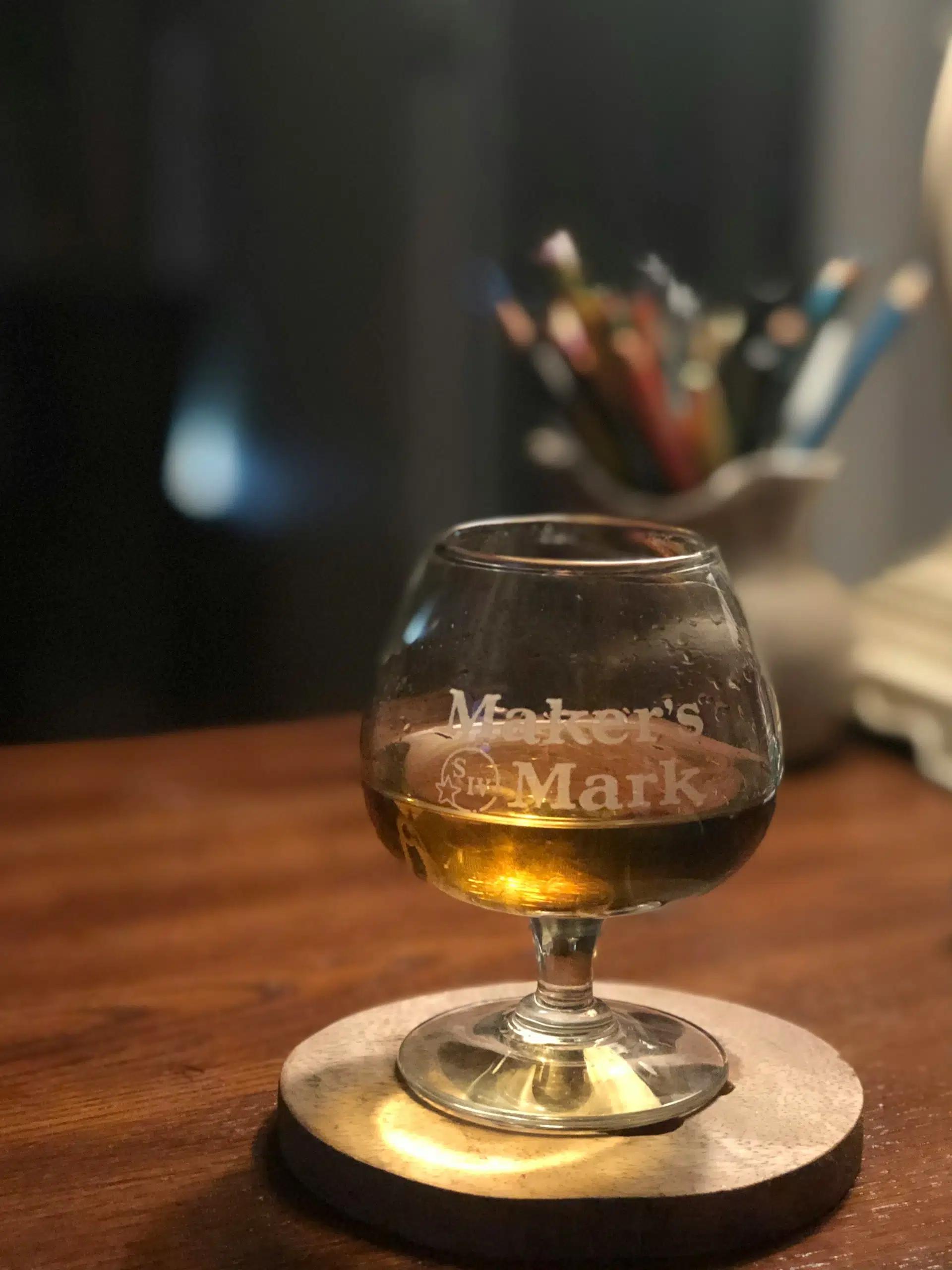 A snifter glass with chilled whiskey inside