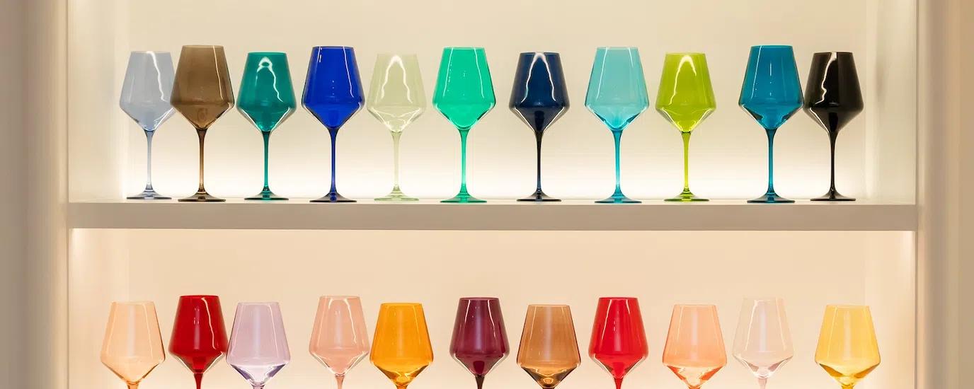 A shelf filled with Estelle colored wine glasses