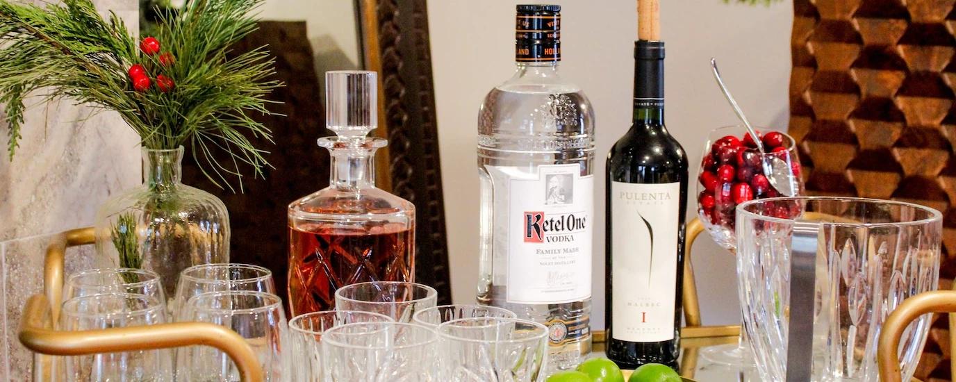 Elegant holiday bar cart setup with spirits, glasses, and festive decor