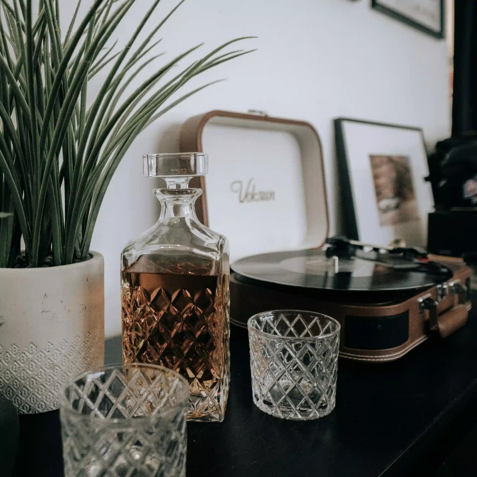 Whiskey decanter with empty whiskey glasses on a table