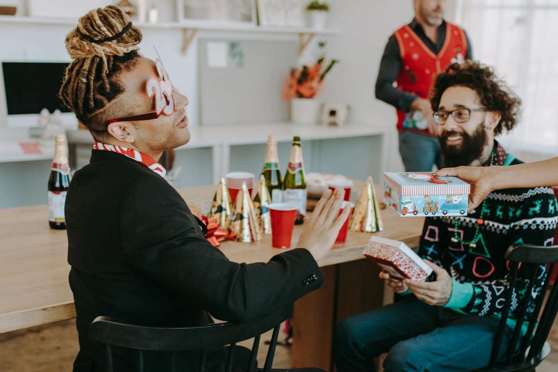 Colleagues celebrating the holidays with gift exchange and champagne at an office party