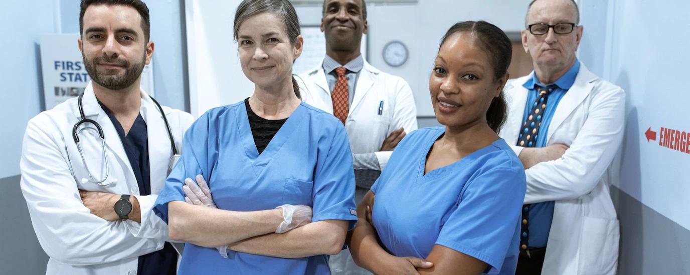 A diverse team of doctors and nurses smiling confidently in a hospital setting