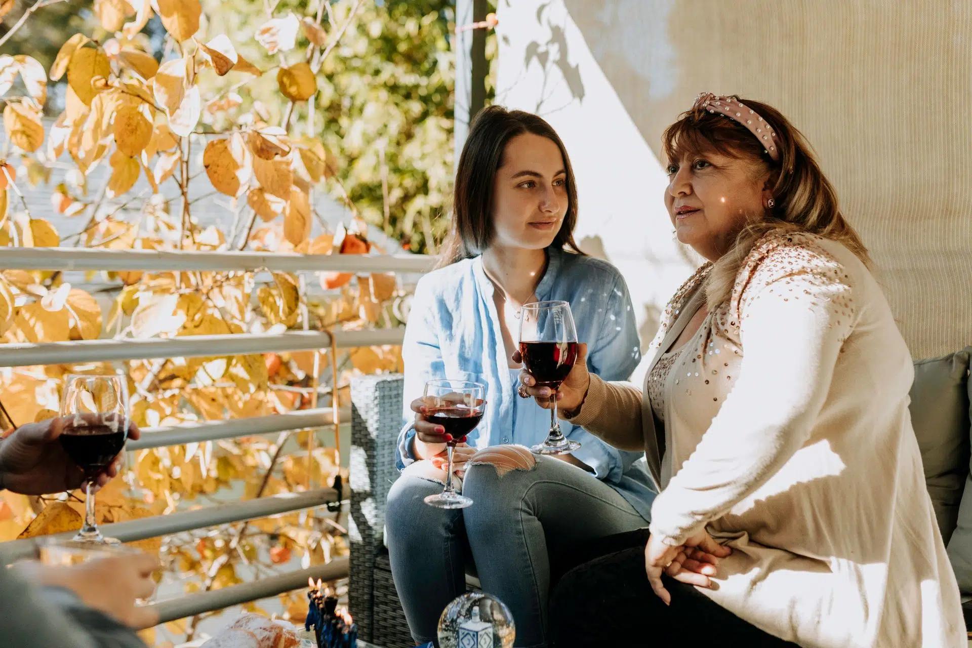 Mother and daughter having wine together out on their porch