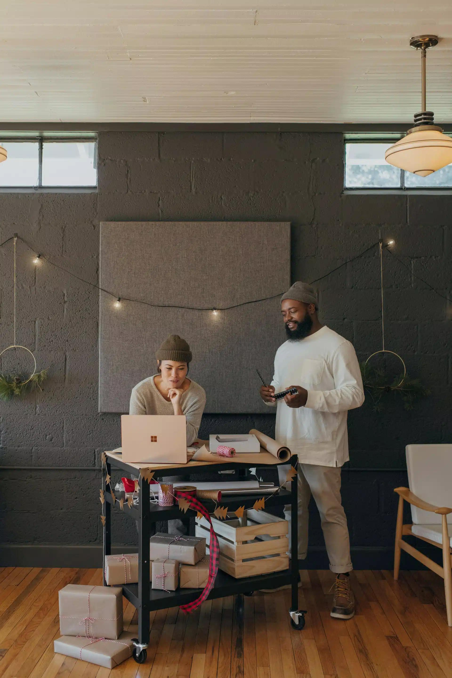 Two persons talking in an office while wrapping gifts