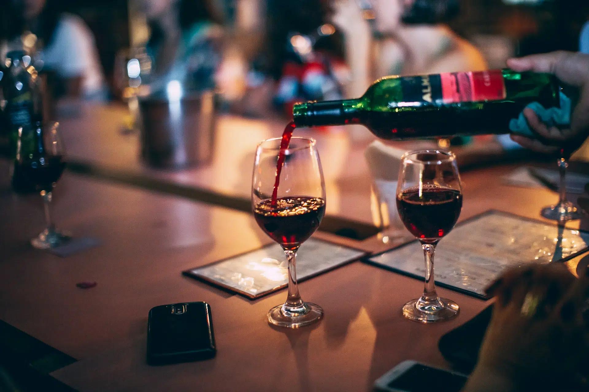 Pouring red wine into a glass on a table