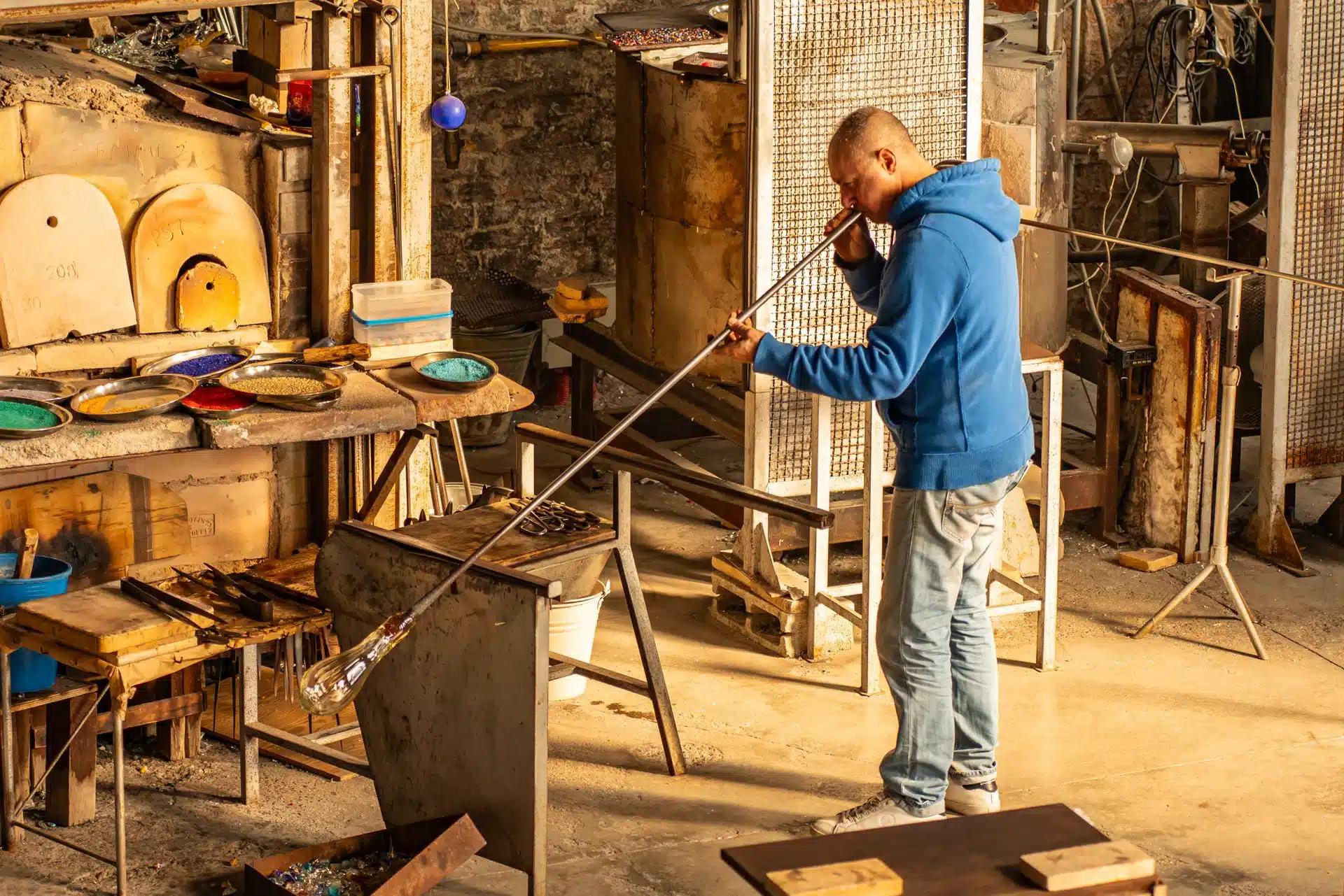 Artisan glassblower crafting glass in a traditional workshop in Venice, Italy