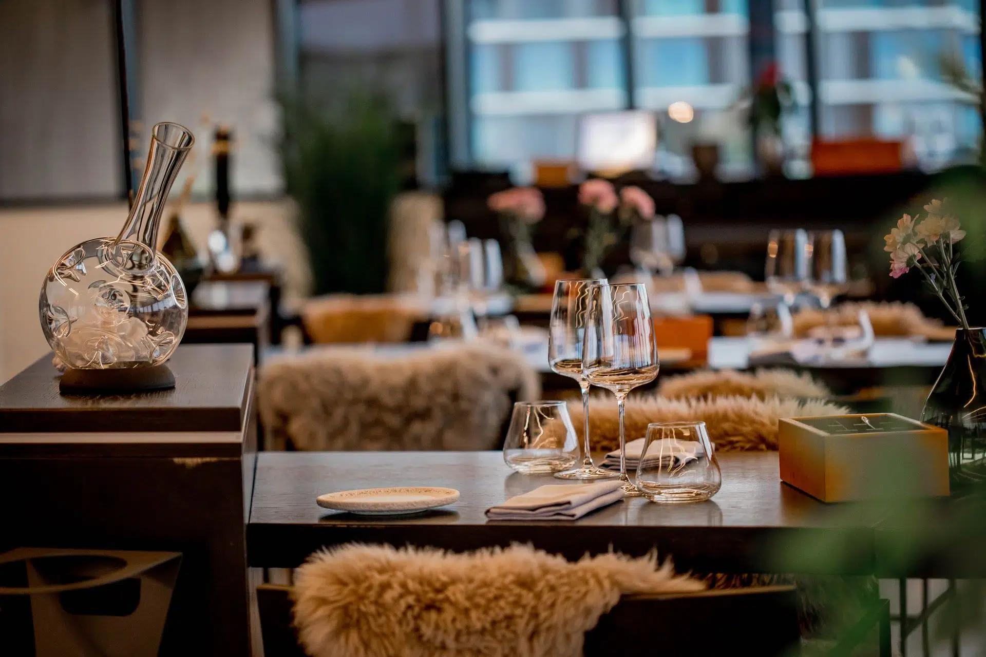 Chic restaurant interior featuring elegant glassware, tableware, and cozy decor
