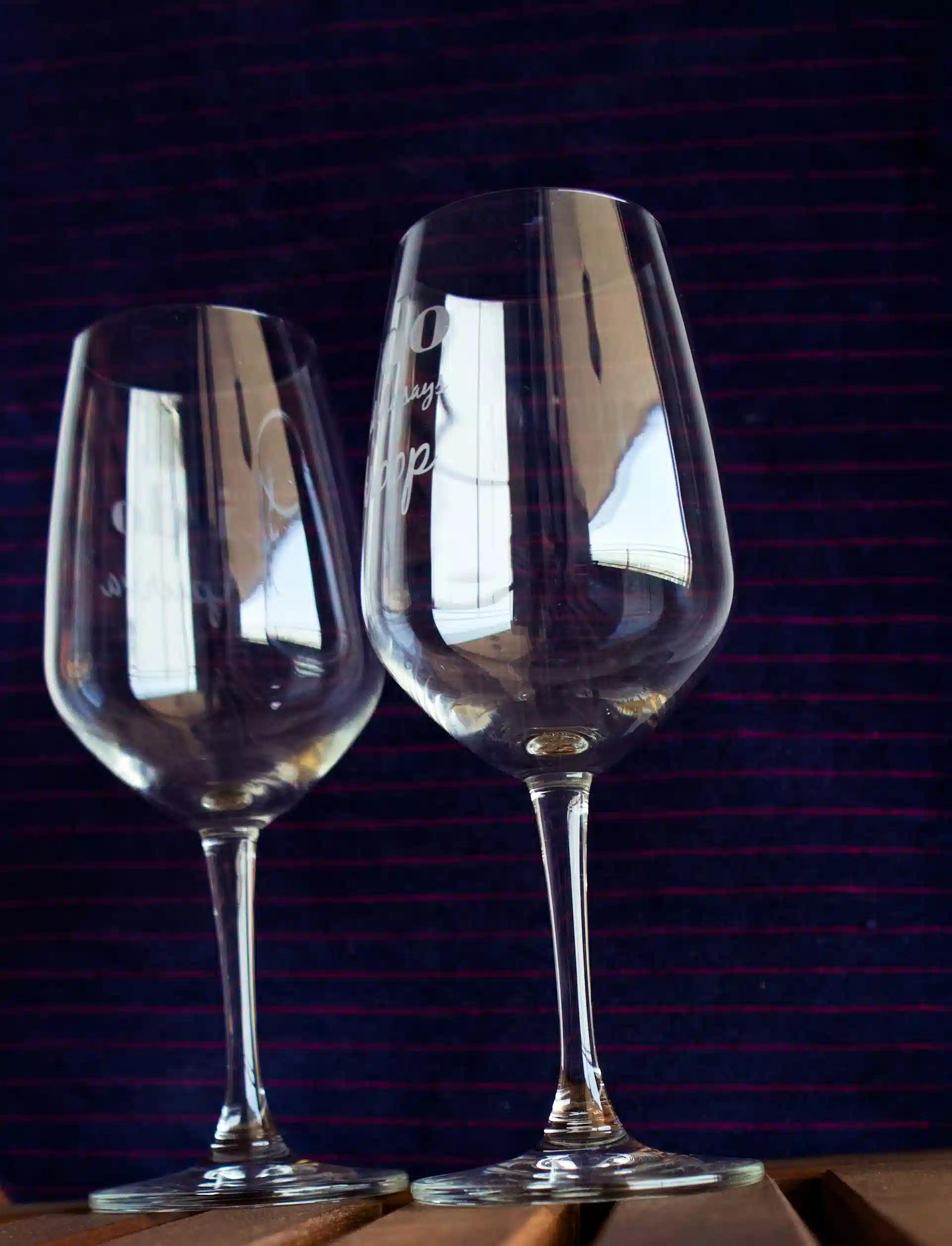 A couple of engraved wine glasses against a black background