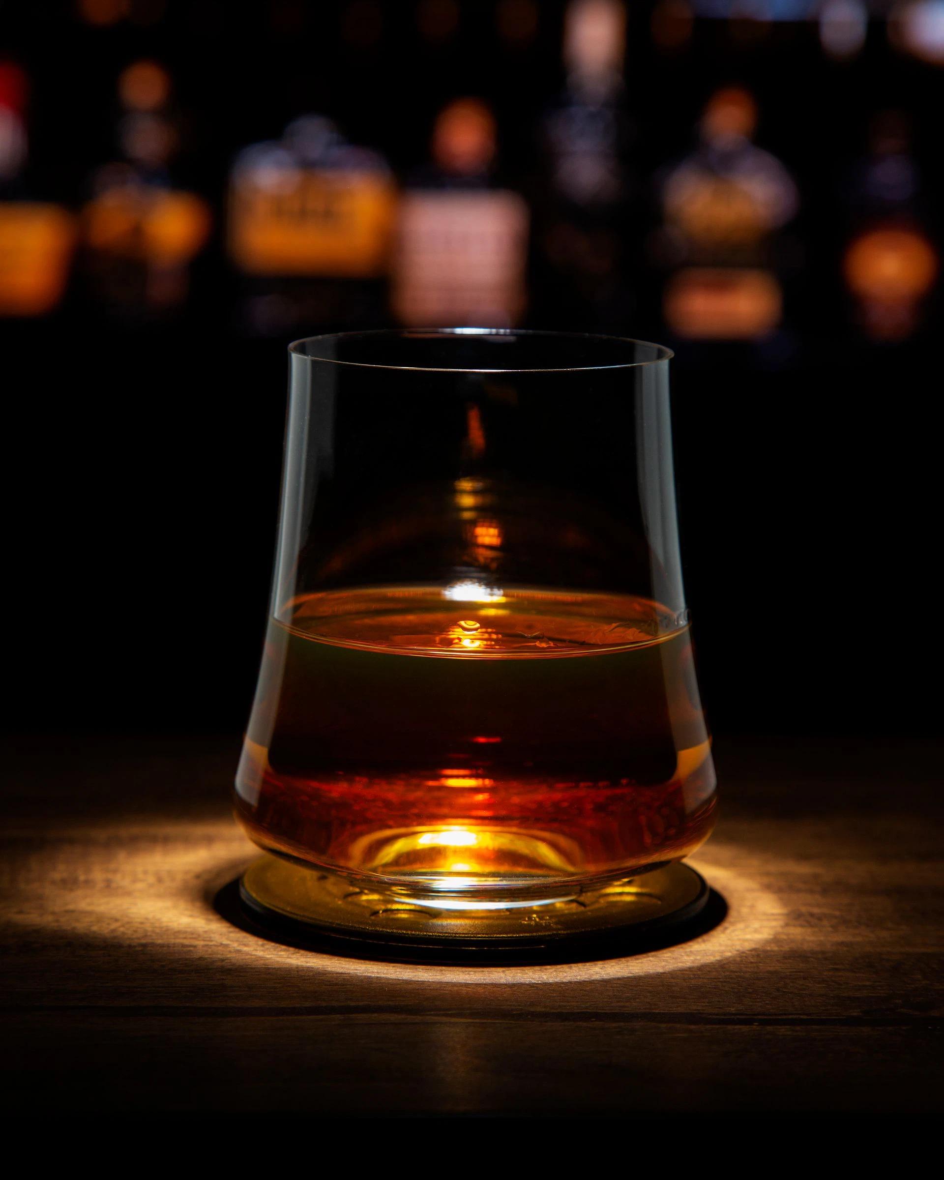 Whiskey glass with rotating or spinning base
