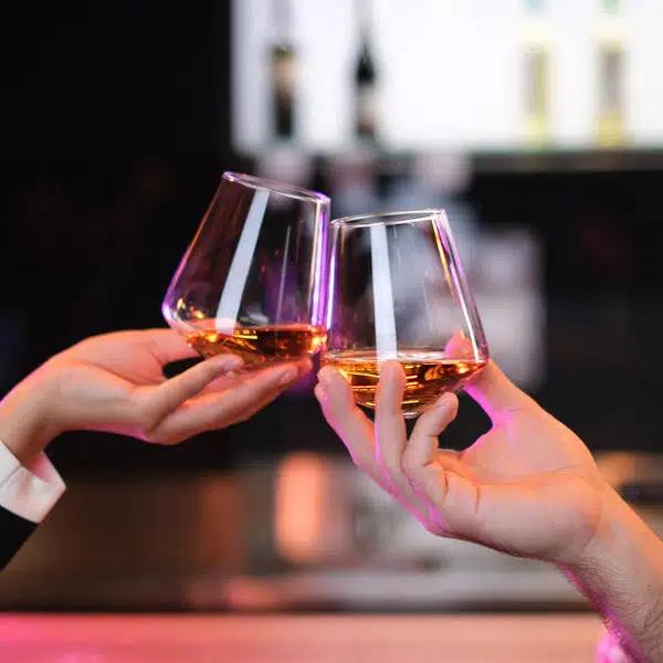 Two hands toasting using the Aequilbrium Universal Glass